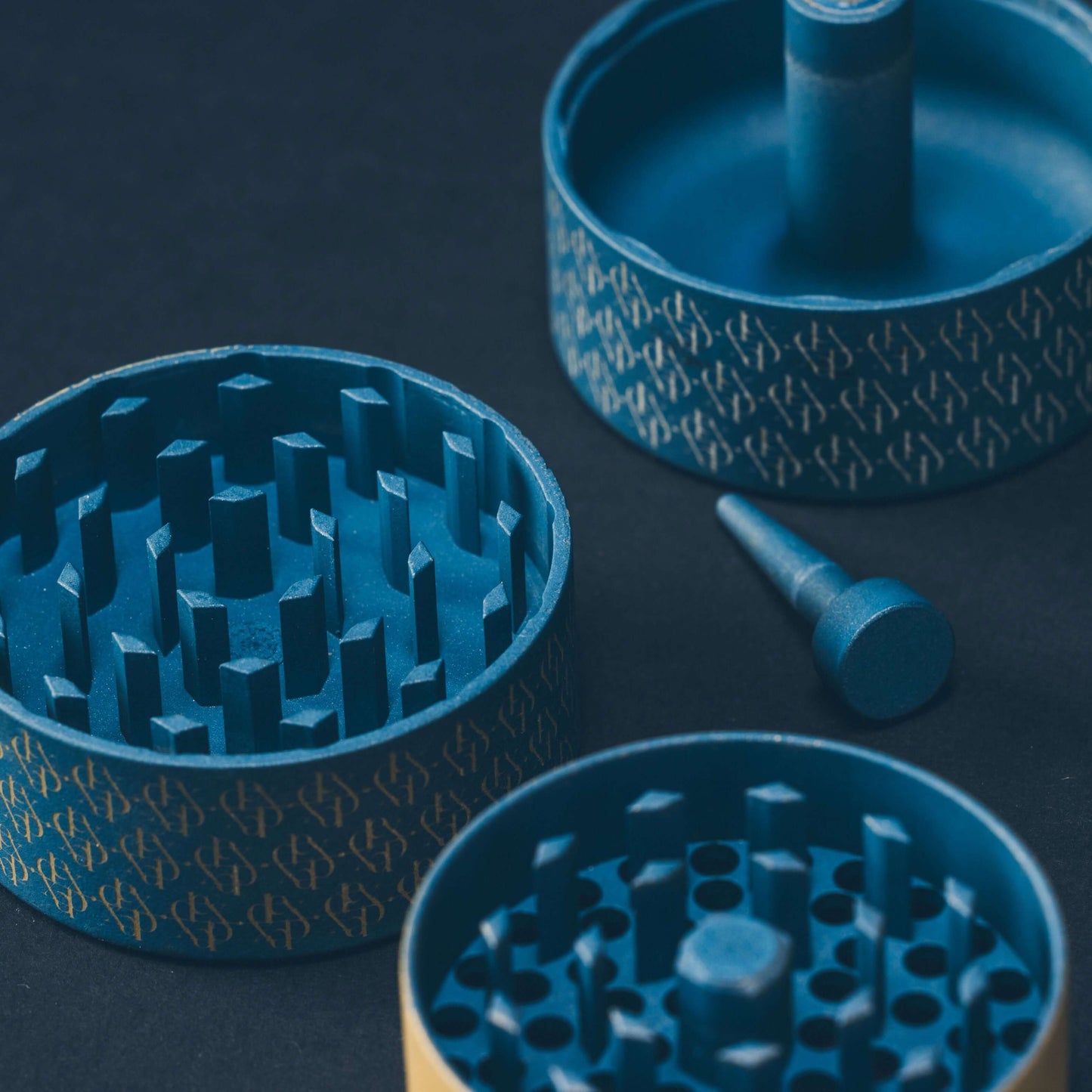Dexter Grinder in slate blue and gold, showcasing high-grade aluminum and Arkansas Diamond Teeth for precision grinding.