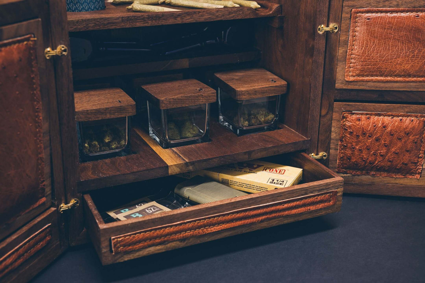Wooden cabinet with glass jars and a drawer holding various items, showcasing a rustic storage design.