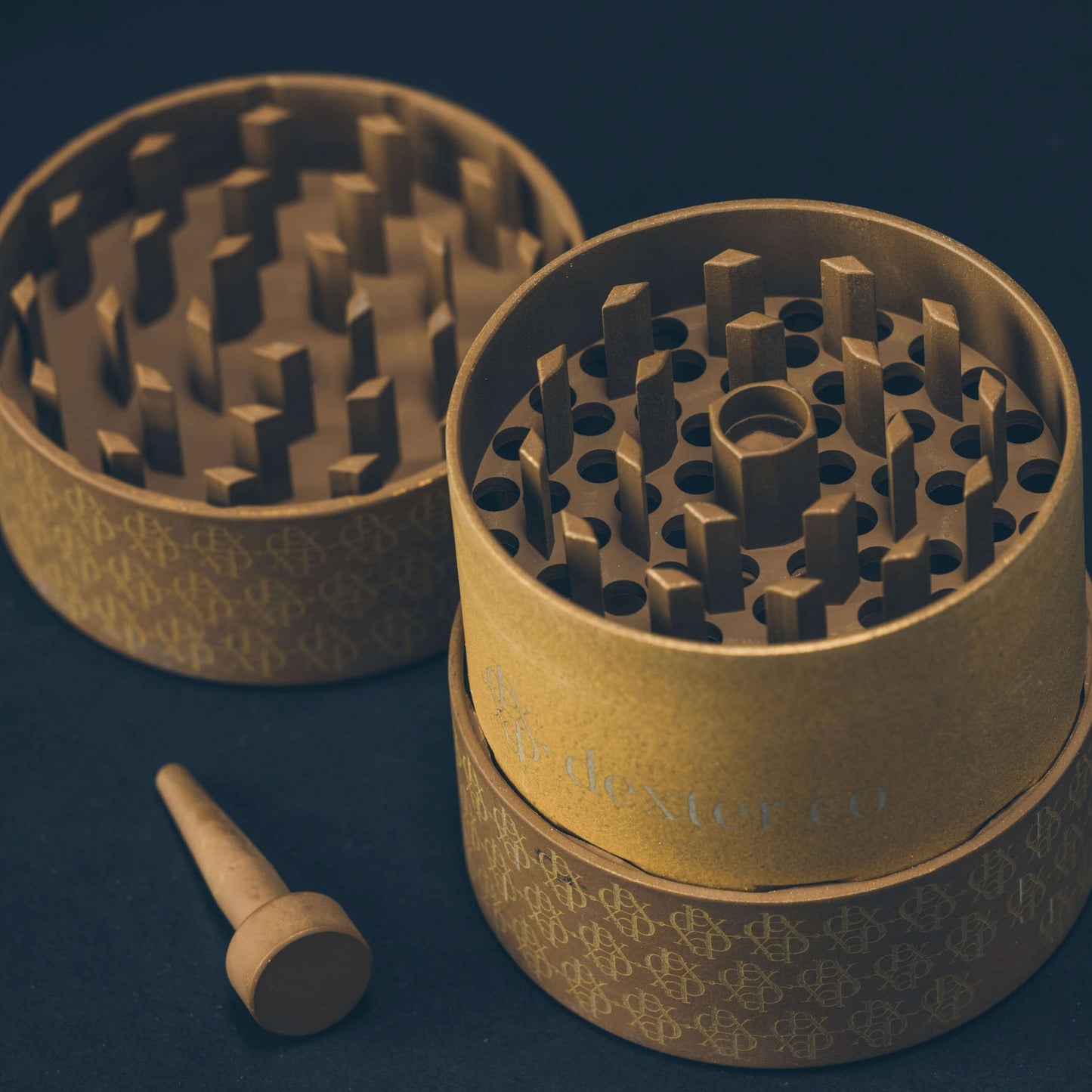 Dexter Grinder in taupe and gold, showcasing innovative design and Arkansas Diamond Teeth for premium cannabis grinding.