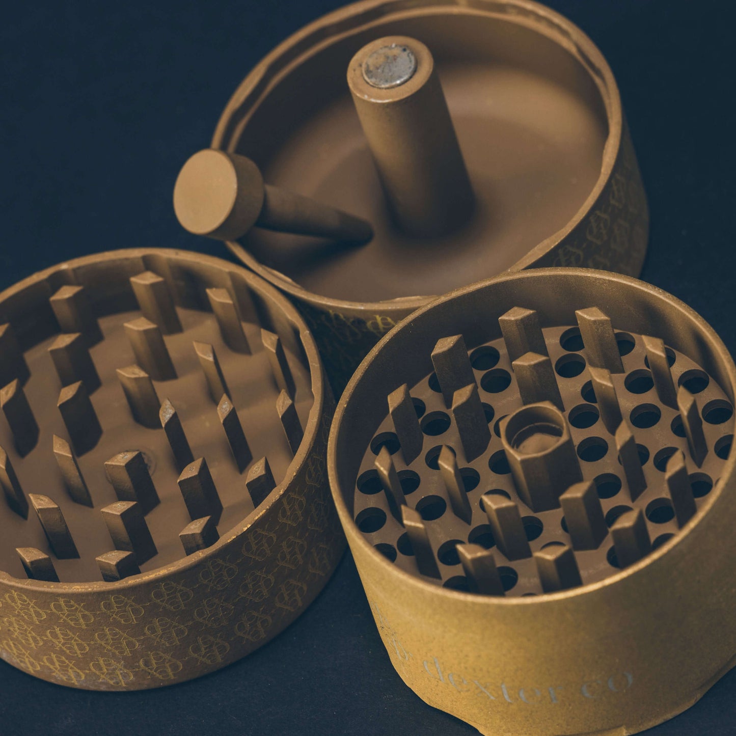 Dexter Grinder in taupe and gold, showcasing threadless design, Arkansas Diamond Teeth, and built-in poker.