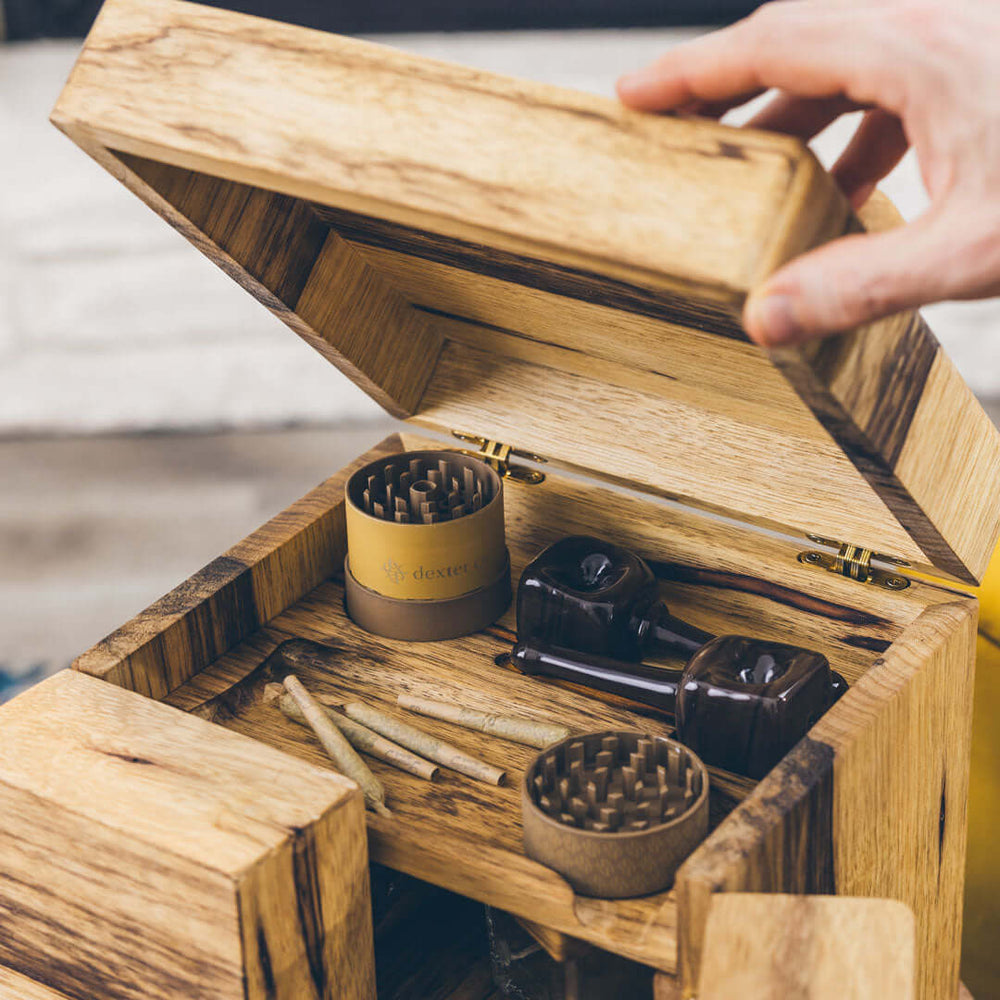 Dexter Co Cube with pre-rolls, grinder, and pipes in light wood finish