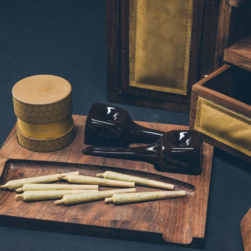 Dexter Co pre-rolls, grinder, and pipes on luxury cannabis tray
