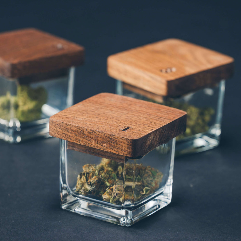 Artisanal strain jars with wooden lids for premium cannabis storage and elegant flower preservation.